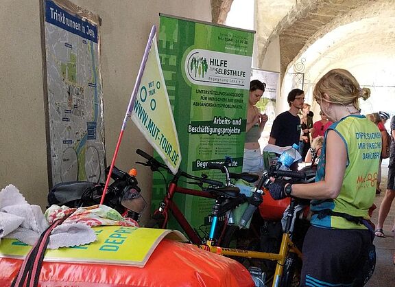 Teilnehmerin der Mut-Tour steht neben ihrem Tandem