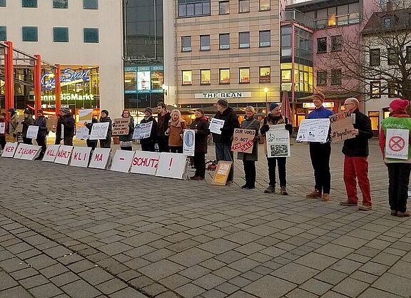 Eine Reihe vom Menschen hält Plakate in die Höhe