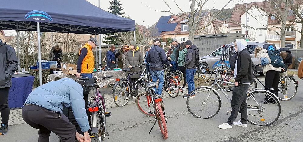 Menschen beugen sich über Fahrräder und diskutieren miteinander