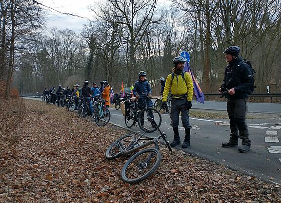 Radfahrer machen an einer Straße halt.