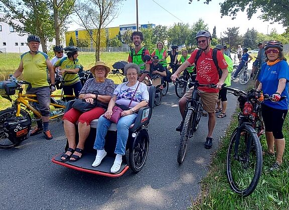 Menschen mit Fahrrädern, Tandems und Rikschas