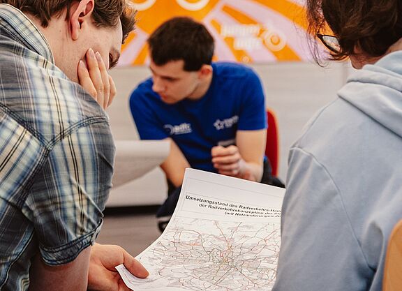 Menschen betrachten und analysieren ein Radverkehrskonzept.