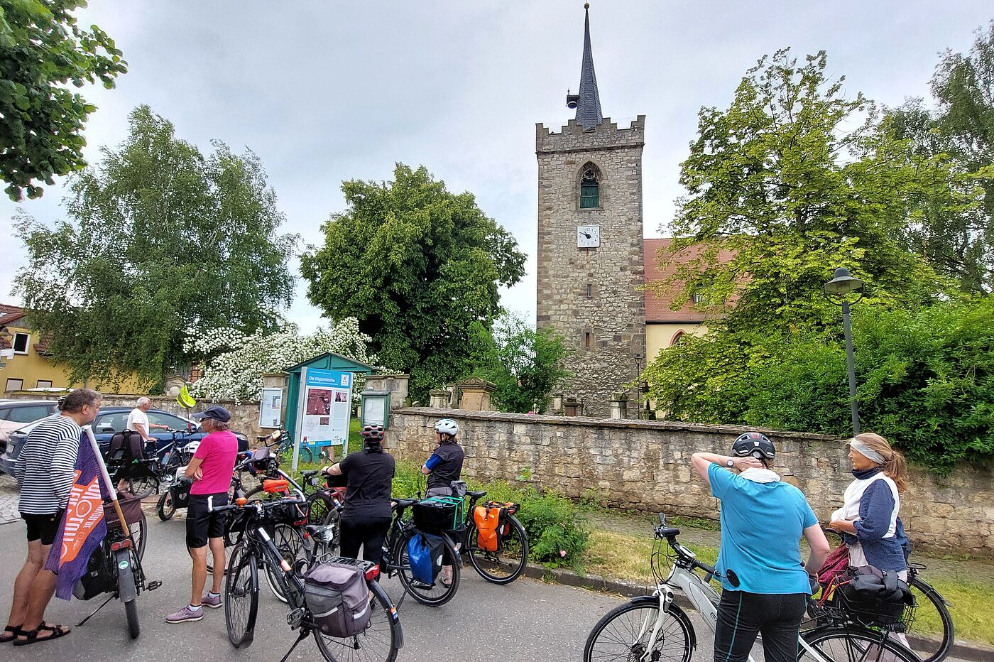 Gruppe von Radfahrenden vor der Kirche in Niederzimmern.