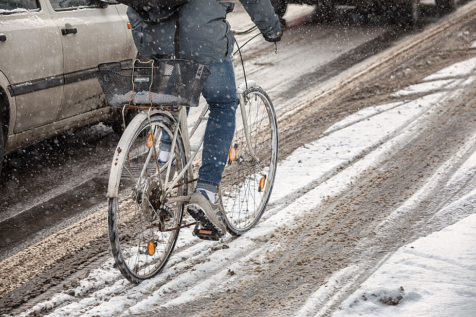 Geräumte Radwege begünstigen Radfahren im ganzen Jahr Radfahrer im Schnee im Straßenverkehr
