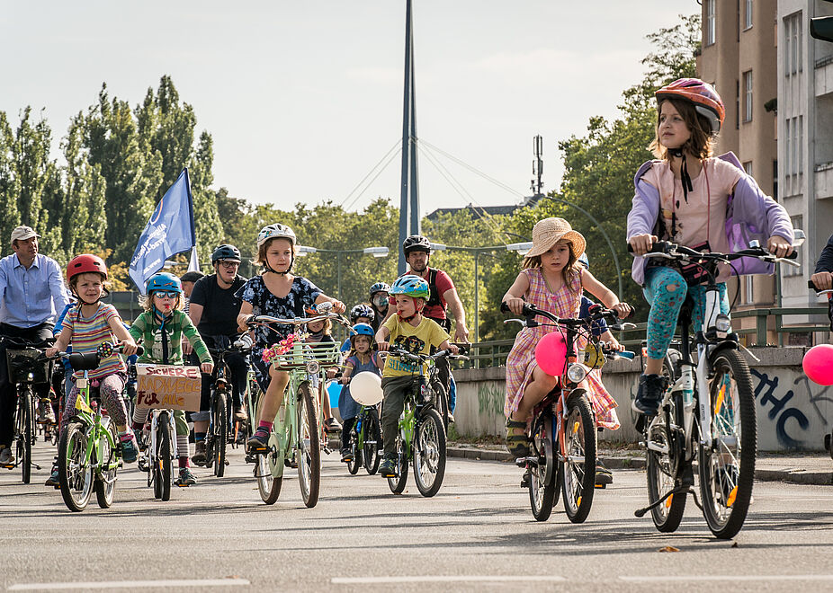 Kidical Mass in Berlin 2020 zahlreiche Kinder auf Fahrrädern mit Luftballons und Fahnen in Berlin